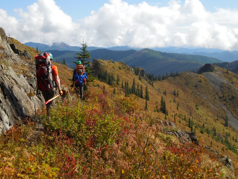Two volunteers admire a log they cut out of the trail.