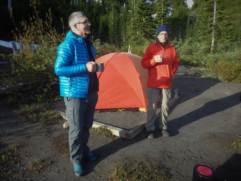 Coffee in camp. Photo by Randy Givens. Two campers drinking coffee by their tent in the morning.