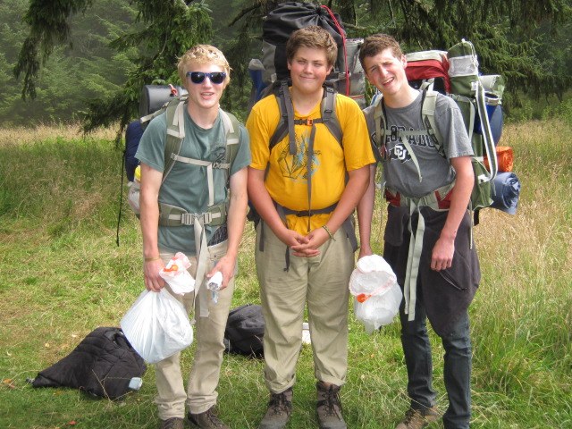 Packing out garbage. Photo by Lucy Nesse. Three hikers packing out garbage.