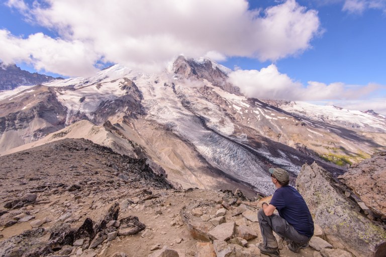 A hiker admires Mount Rainier from Burroughs Mountain.