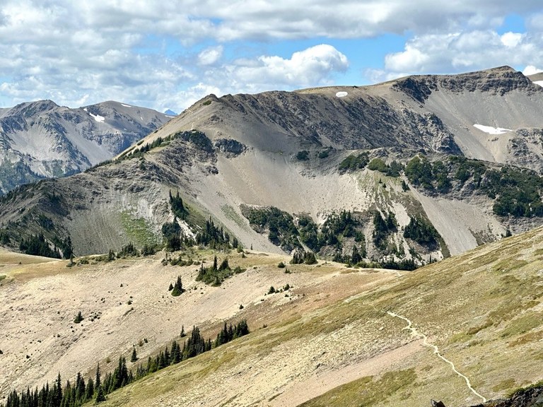 Expansive mountain views with a trail running through the foreground. Photo by ZhuckYu. 