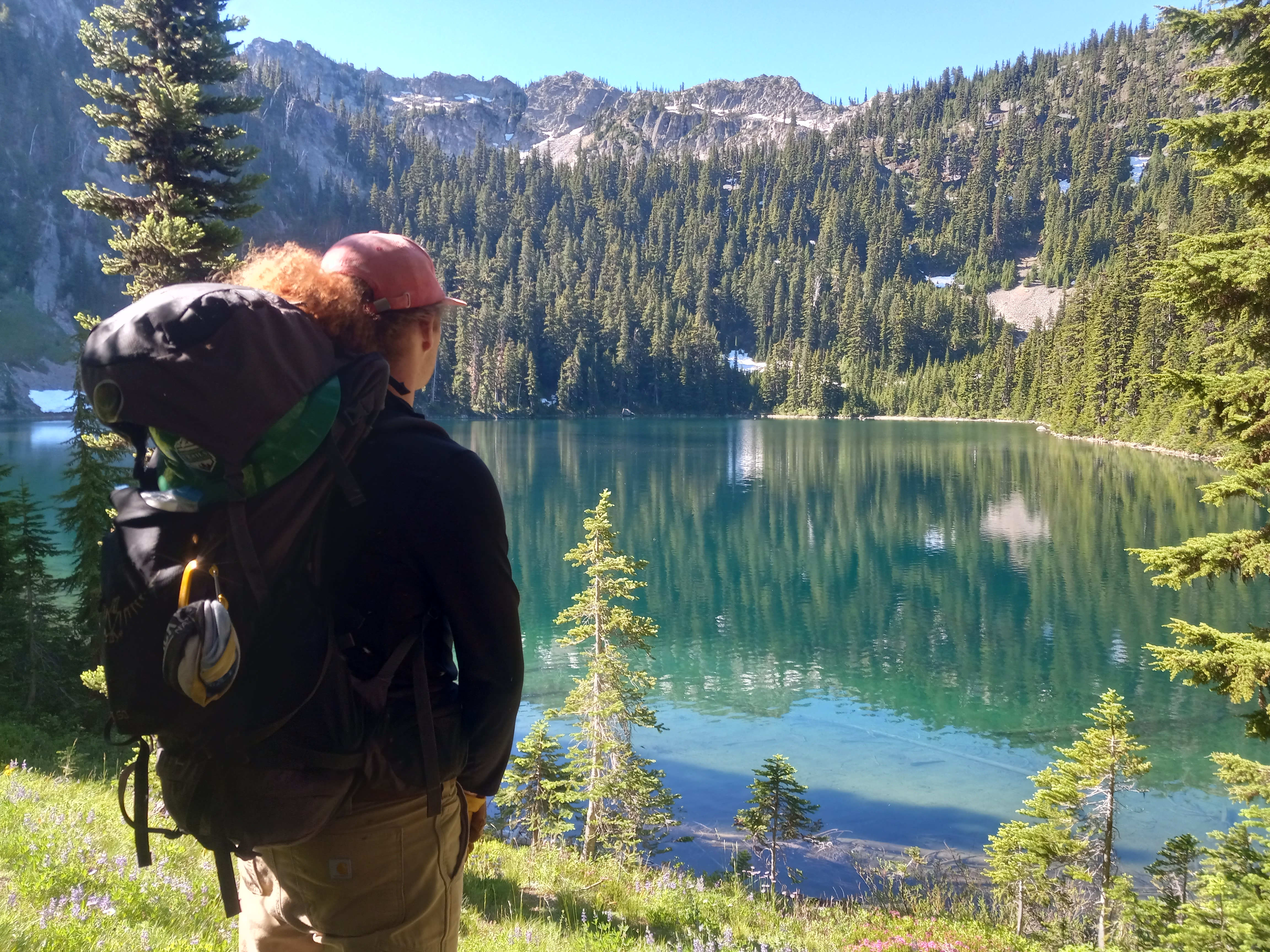 standing admiring MIchael Lake Melissa Davis A backpacker stands in the left foreground admiring a large blue-green lake.