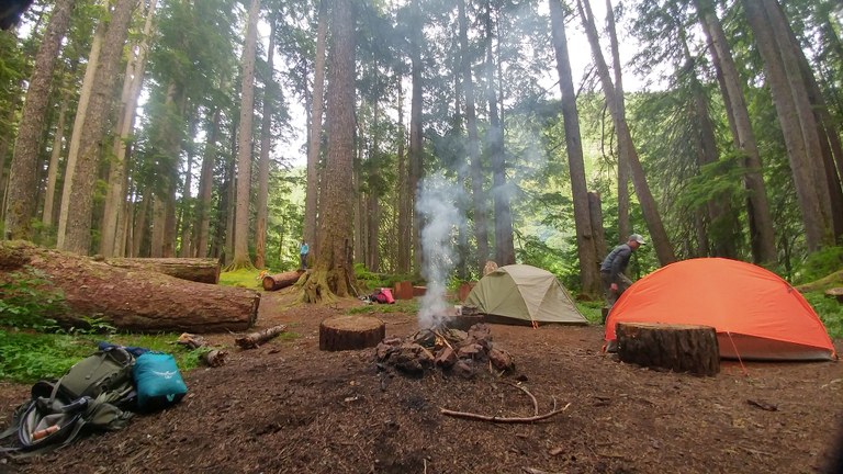 Sink Lake campsite A campsite with tents, a campfire and a couple of people enjoying the area.