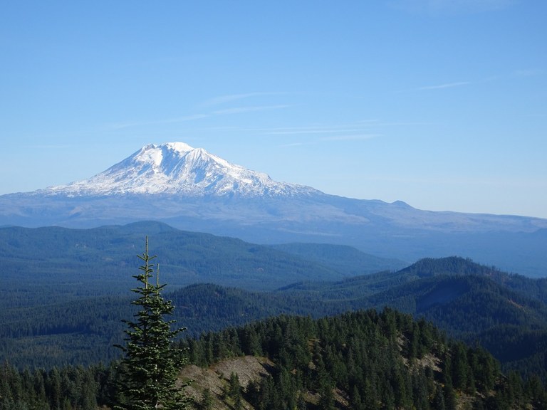 A snow-covered volcano rising from the flat valley. 