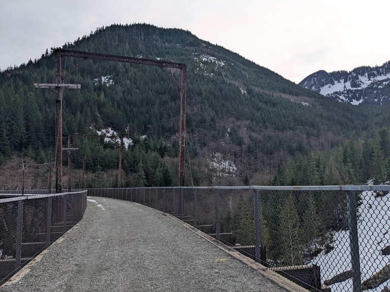 A high trestle bridge spans the gap between two mountain ridges.