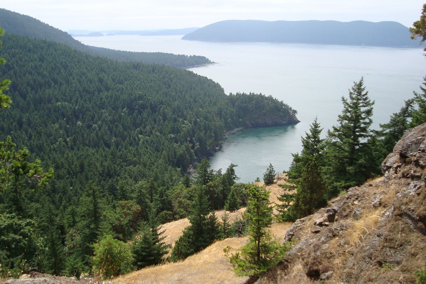 View down to tree-covered coastline and across the water to other islands