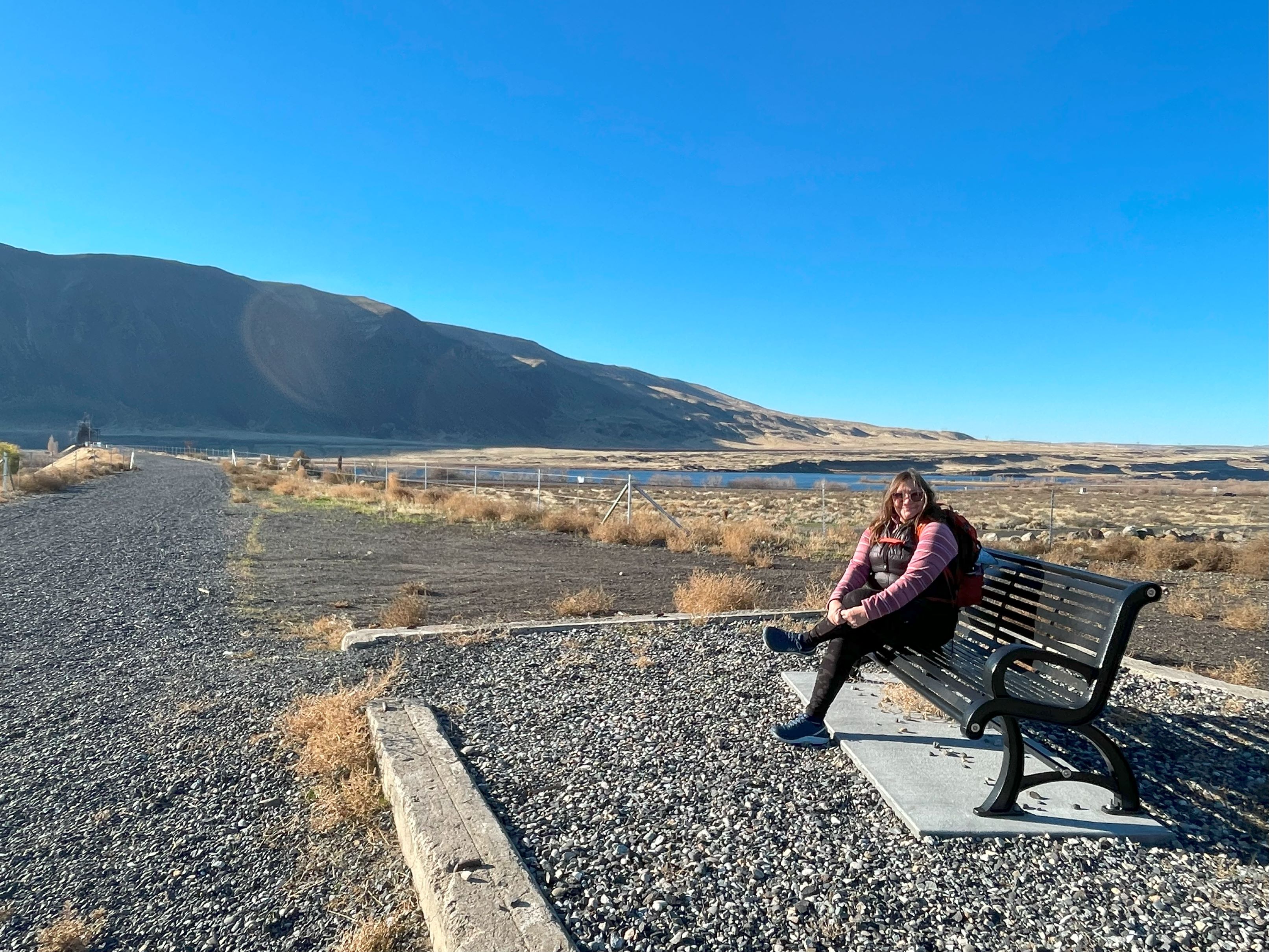 A hiker sits on a bench on one end of the Beverly Bridge, on the Palouse to Cascades Trail. Photo by Holly Weiler.