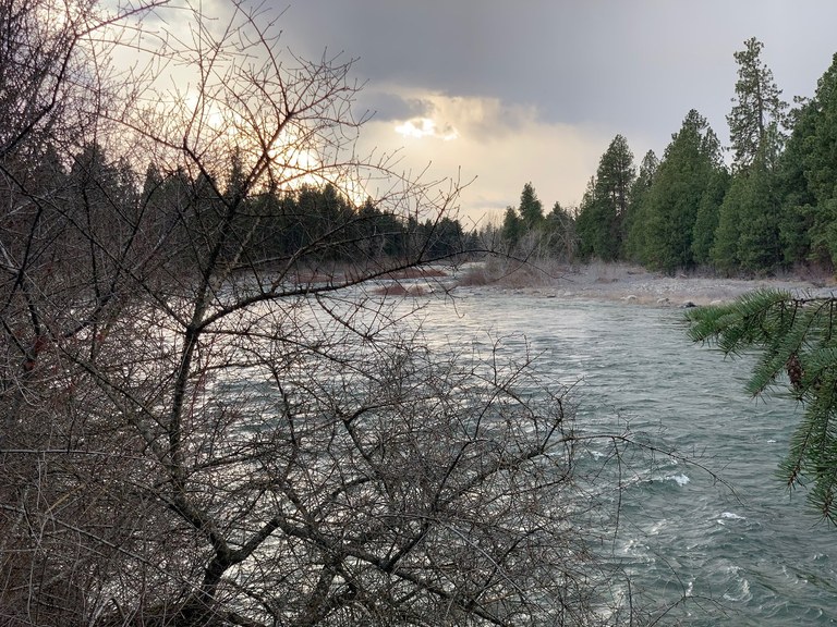 A wide, rushing river under a large, cloudy sky