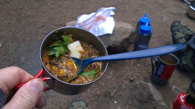 A soup pot filled with chili and accented with cilantro. 