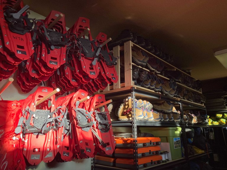 Snowshoes at the WTA Puyallup Gear Library. Photo by MJ Sampang. WTA snowshoes hang against a wall.