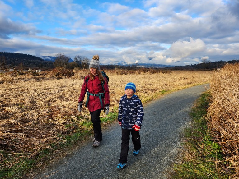 Two hikers walk down a path.