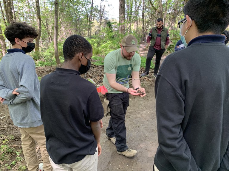 Kaci holds up soil to show a group of volunteers. 