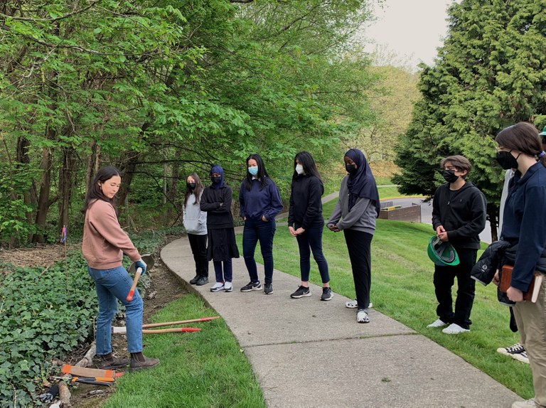 Leina describes tools to a group of volunteers.