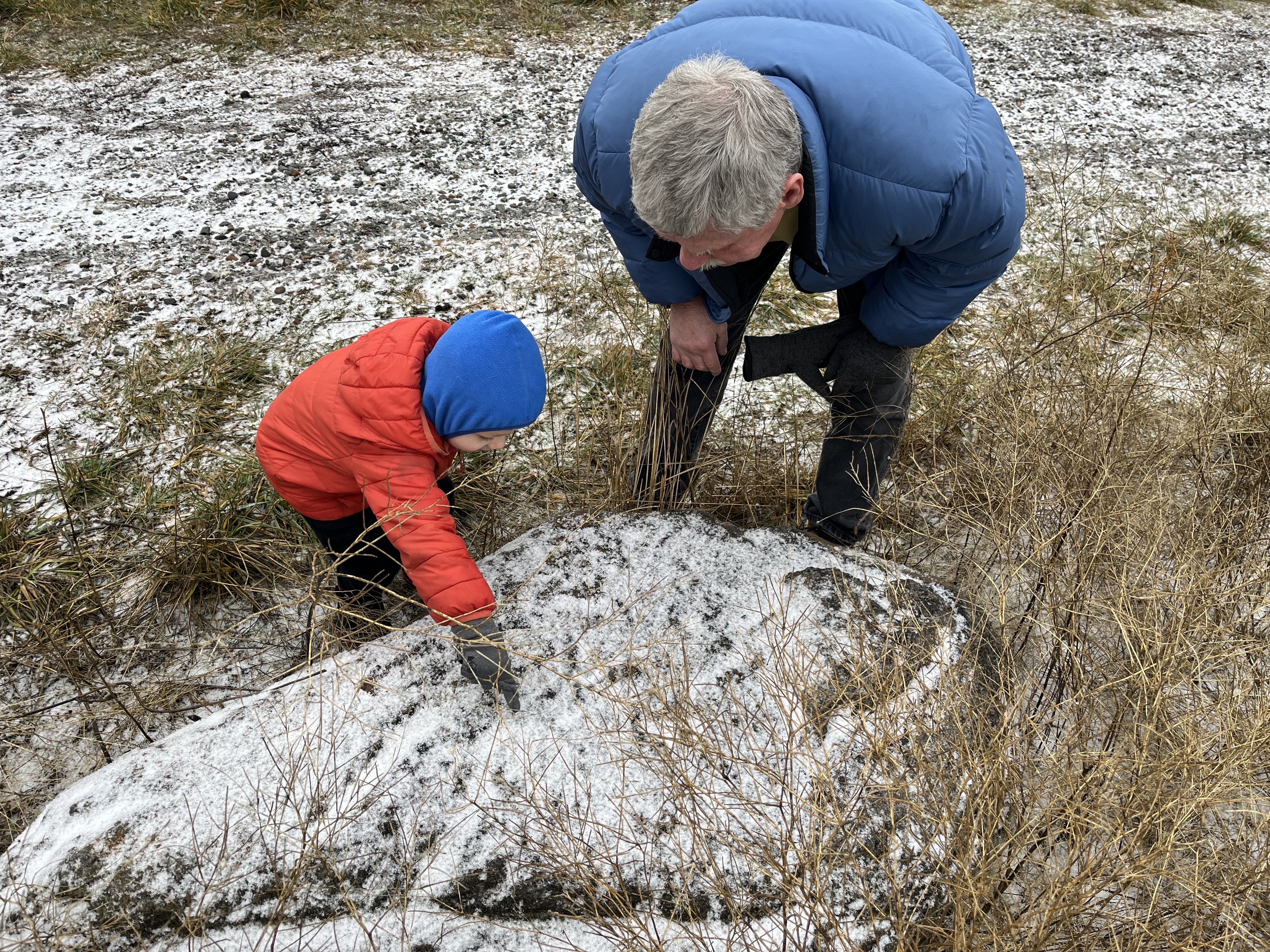 A grandfather and child look for tracks