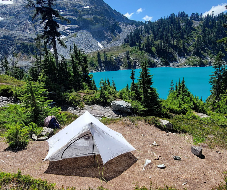 A tent is pitched on a bare patch of ground near Jade Lake.