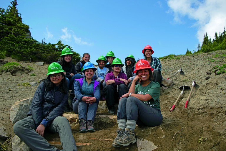 A group of youth volunteers with Latino Outdoors pose on trail steps they've built.