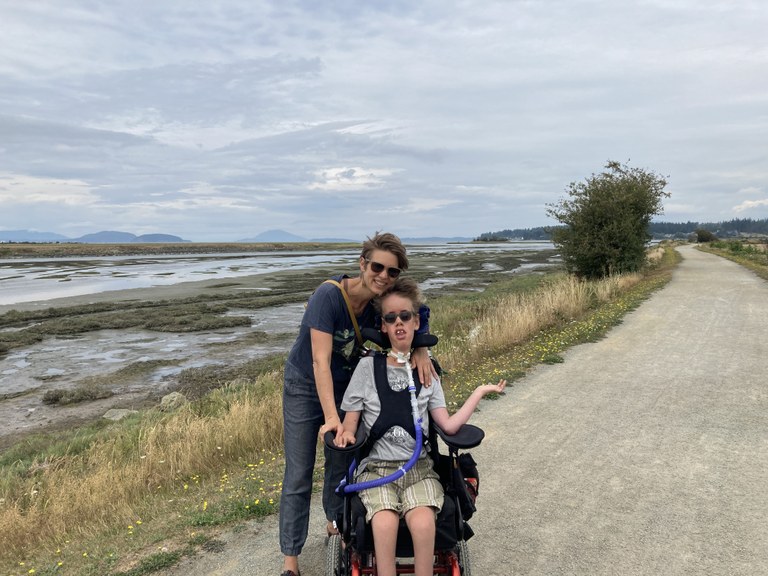 Two hikers pose for a photo on a hardpacked dirt trail at Padilla Bay.