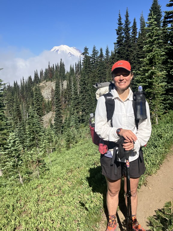 A backpacker stands on trail.