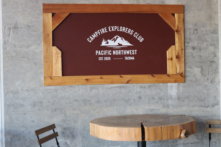 A wooden sign reading "Campfire Explorer's Club" 