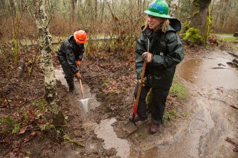 Volunteers embrace the mud as they build a drain dip at Soaring Eagle Regional Park.