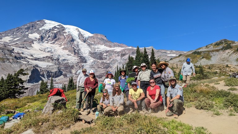 LO volunteers and Mount Rainier National Park staff pose for a photo with Mount Rainier in the background.