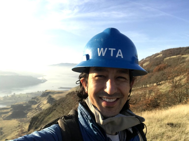 Ryan Ryan taking a selfie on trail while wearing his blue hard hat.