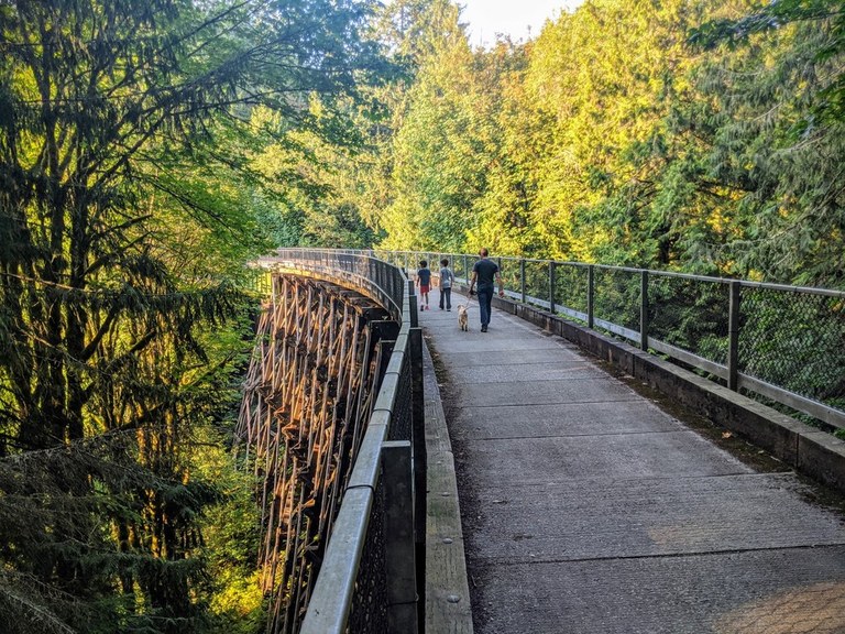 A family walks along the trestle section of the Snoqualmie Valley Trail near the Tokul trailhead.