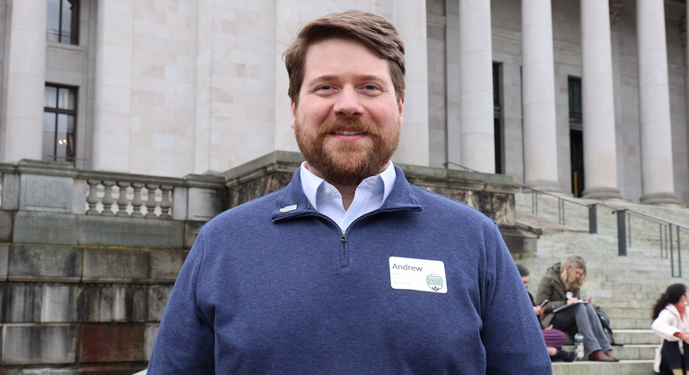 Andrew From A hiker smiles at the camera at the state capitol.