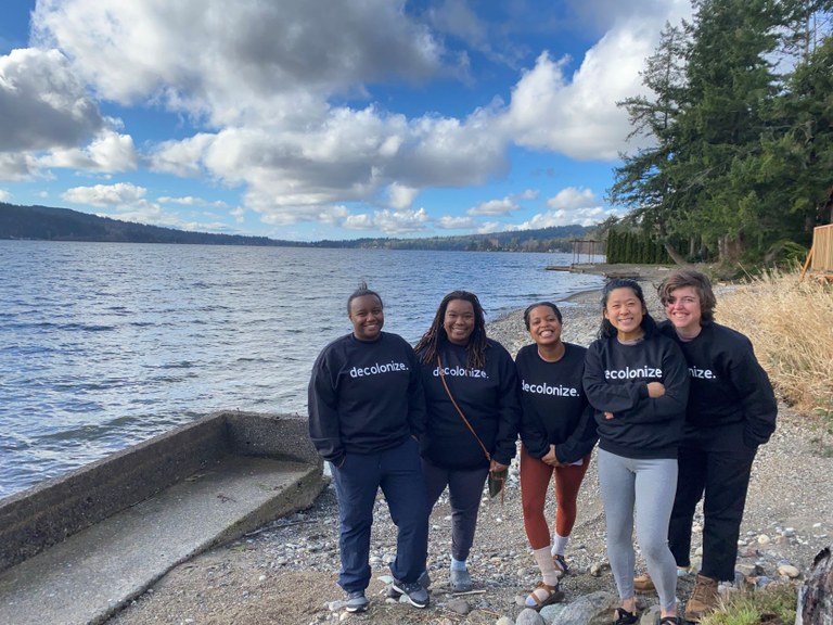 Photo of five hikers standing next to the water. Photo courtesy of Braided Seeds.