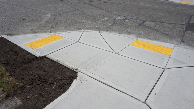 A newly installed curb cut in a sidewalk. 
