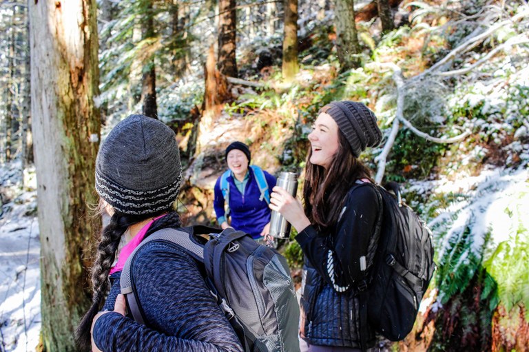 Hikers laughing on a snowy day on the Rattlesnake Ledge/East Peak trail. Photo by Emily Blatter.