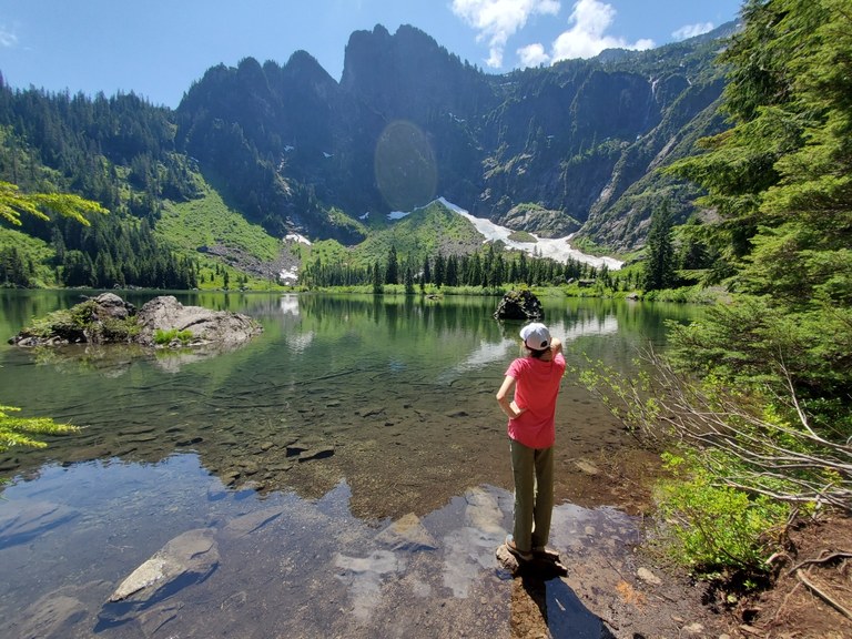 Heather Lake. Photo by Cuppa. Child stands in Heather Lake, looking up at the mountains across the water. Photo by Cuppa.