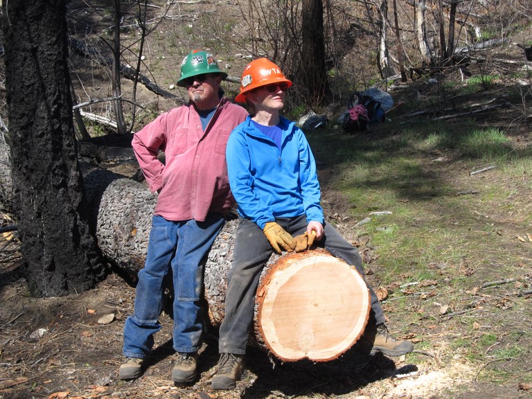 Crosscuts are no problem for Pat and other volunteers. Two volunteers pose on a recently cut log on trail.