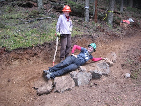 It's important to take a moment to appreciate your hard work. Two volunteers pose next to a section of trail they've completed.