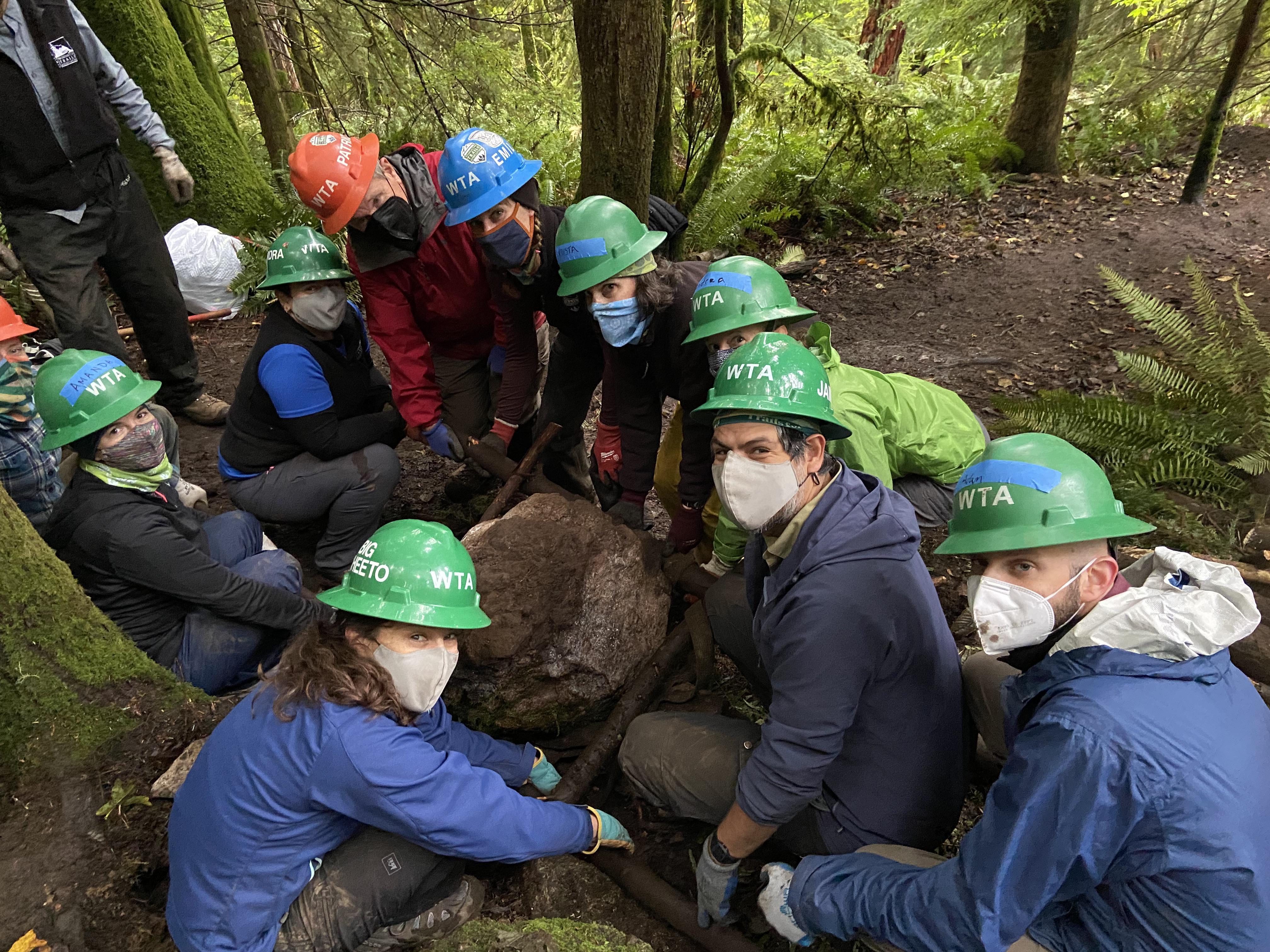 WTA's leadership team including Jill (aka Big Cheeto thanks to her love of a crunchy trail snack) work togehter to move a huge rock on the Poo Poo Point trail.