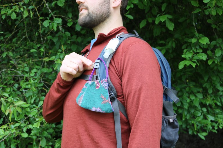 A face covering clipped to a backpack. Photo by Charlie Wakenshaw. 