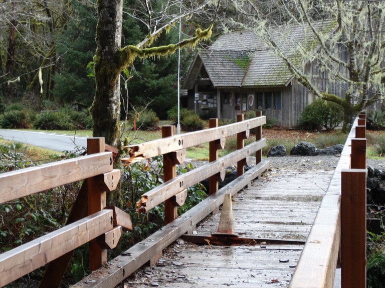 A bridge wooden bridge with a broken section, looking toward an Olympic National Park Ranger Station at the Kestner Homestead. Photo by trip reporter jstorm_57.