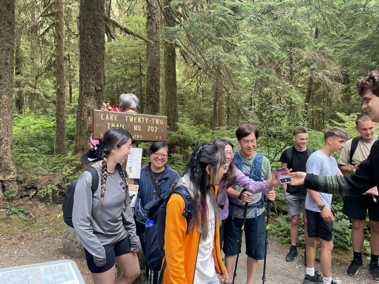 Trail ambassadors help spread resources — and occasionally take group photos for hikers — at trailheads.