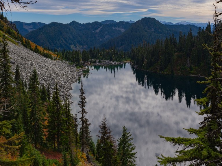 Fall colors around the shimmering Lake Valhalla on a partly cloudy autumn day. Photo by Wanderlust_PNW. 