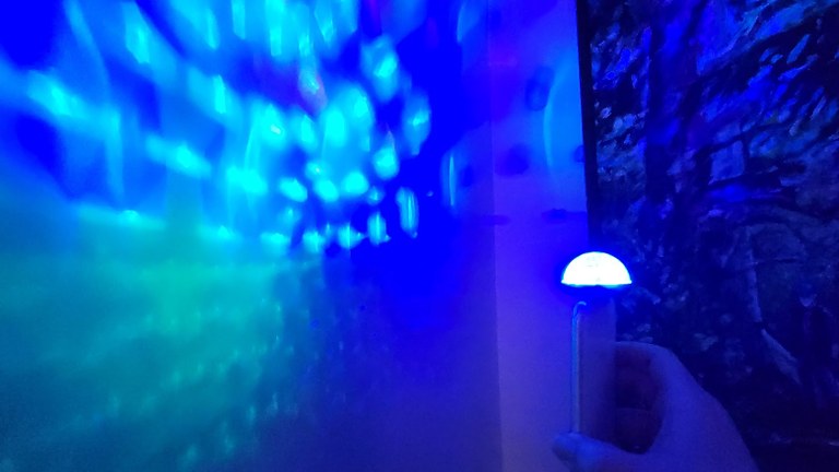A blue disco light illuminates a wall.