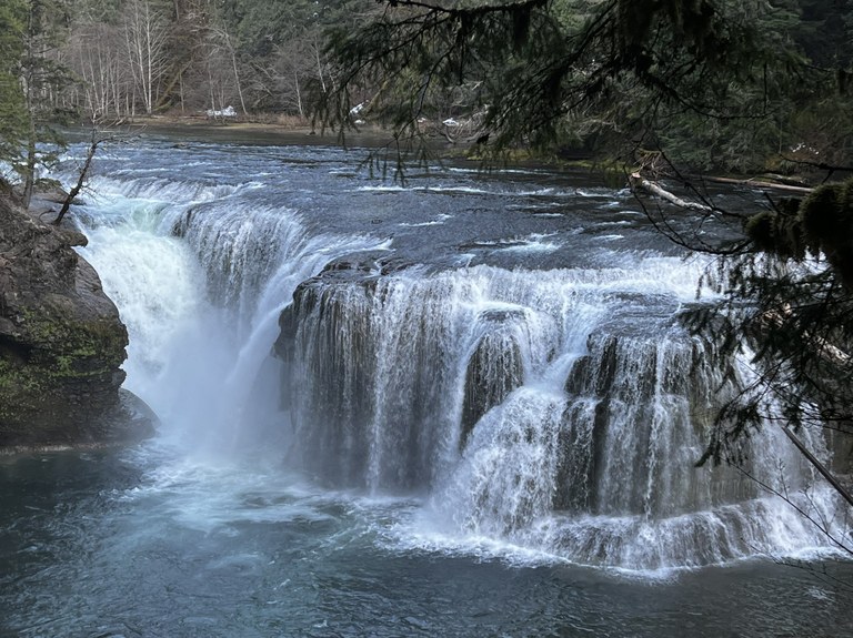 A wide waterfall cascades down into a pool below.