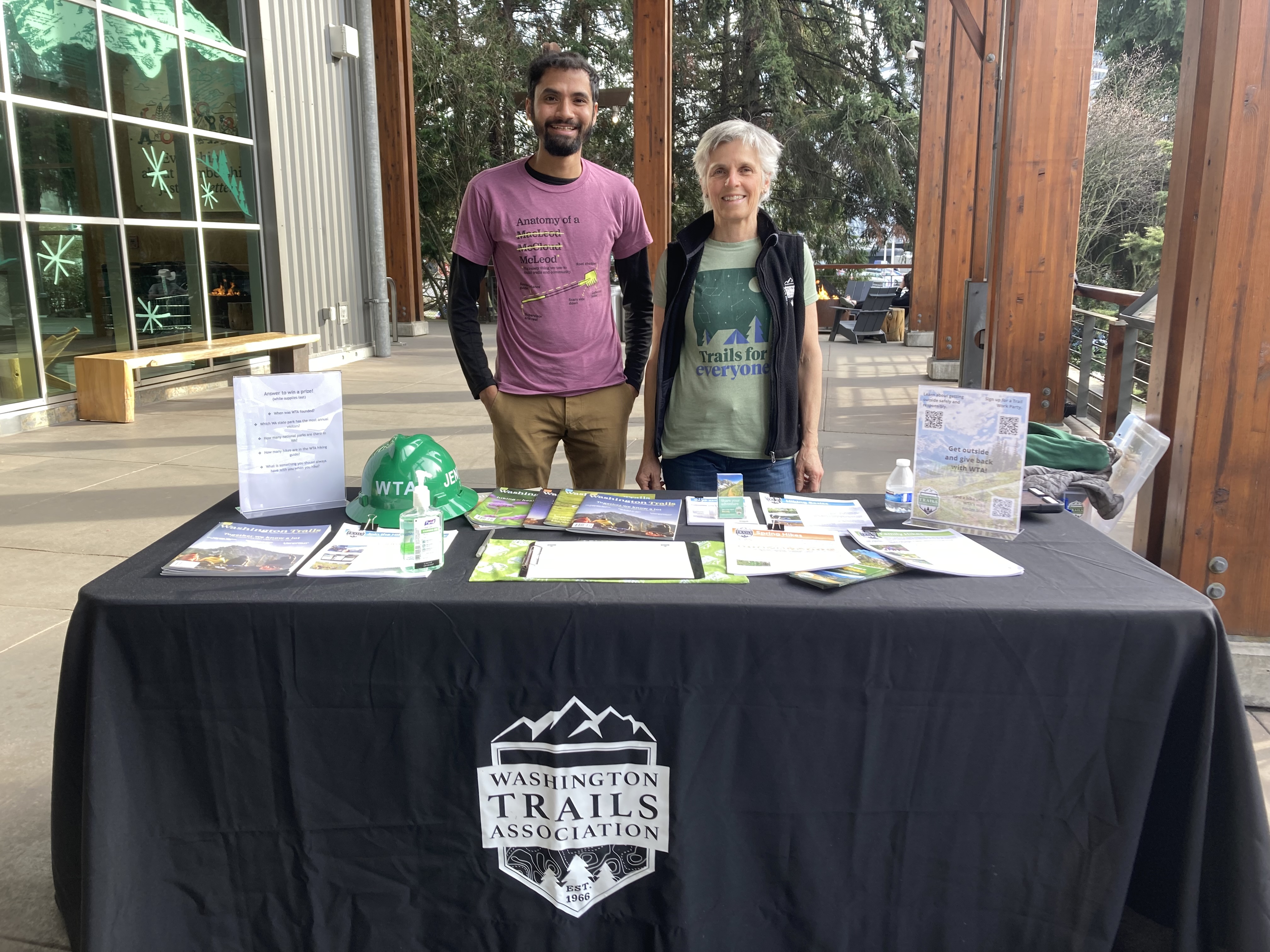 Outreach at REI Two volunteer ambassadors pose behind a WTA outreach table outside of REI in Seattle