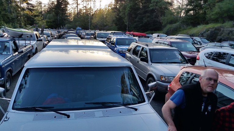 A man walks through a crowded parking lot at the trailhead. Photo by Barbara B. 