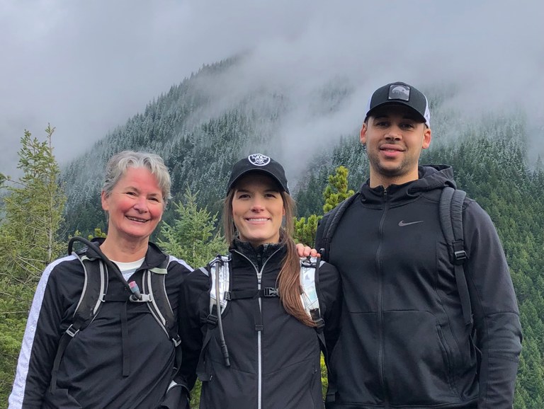 Kris Morrissey with her daughter and son-in-law. Kris Morrissey on a hike with her daughter and son-in-law, smiling at the camera.