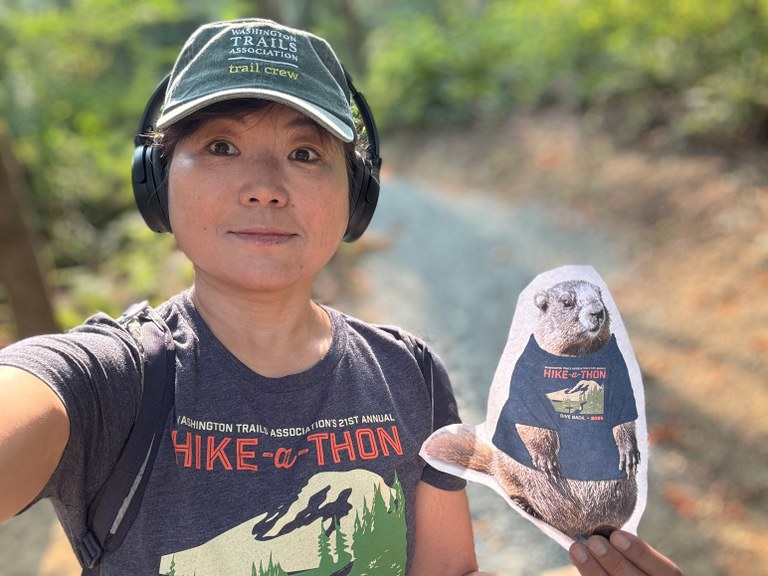 Yoshiko Chomon with Miles the Marmot. Yoshiko Chomon taking a selfie with a cutout with Miles the Marmot.
