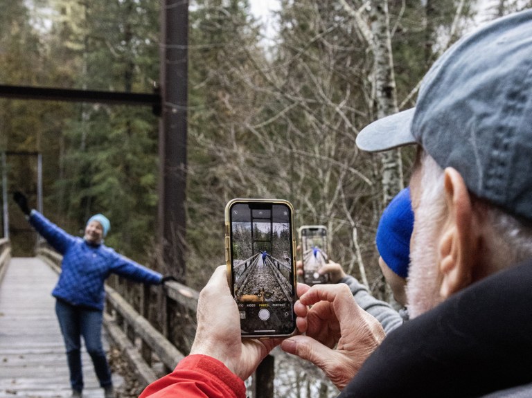 Taking a fun photo! Photo by Annie Melcher. Two hikers taking photos with their phones of another hiker. Photo by Annie Melcher.