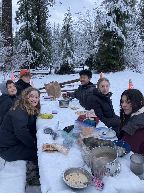 Post 84 winter trip A group of high school students sit at a table on a snowy day.