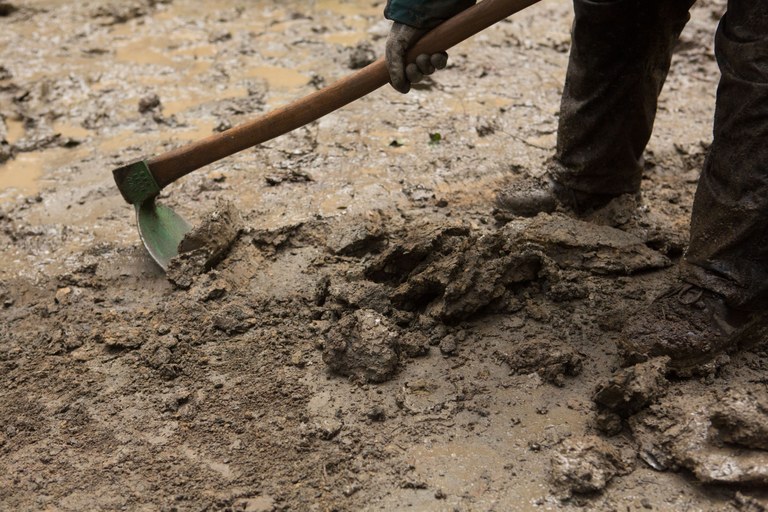 A trail work volunteer works in the mud. Photo by Emma Cassidy. 