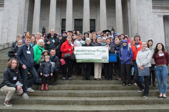 More than 100 advocates braved pouring rain to hike the capitol steps in support of funding for trails. Photo by Erik Haugen-Goodman.