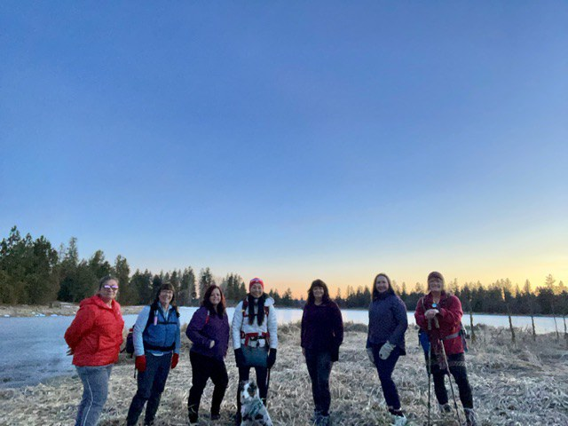 Six friends and one dog stand on the bank of Slavin Pond.
